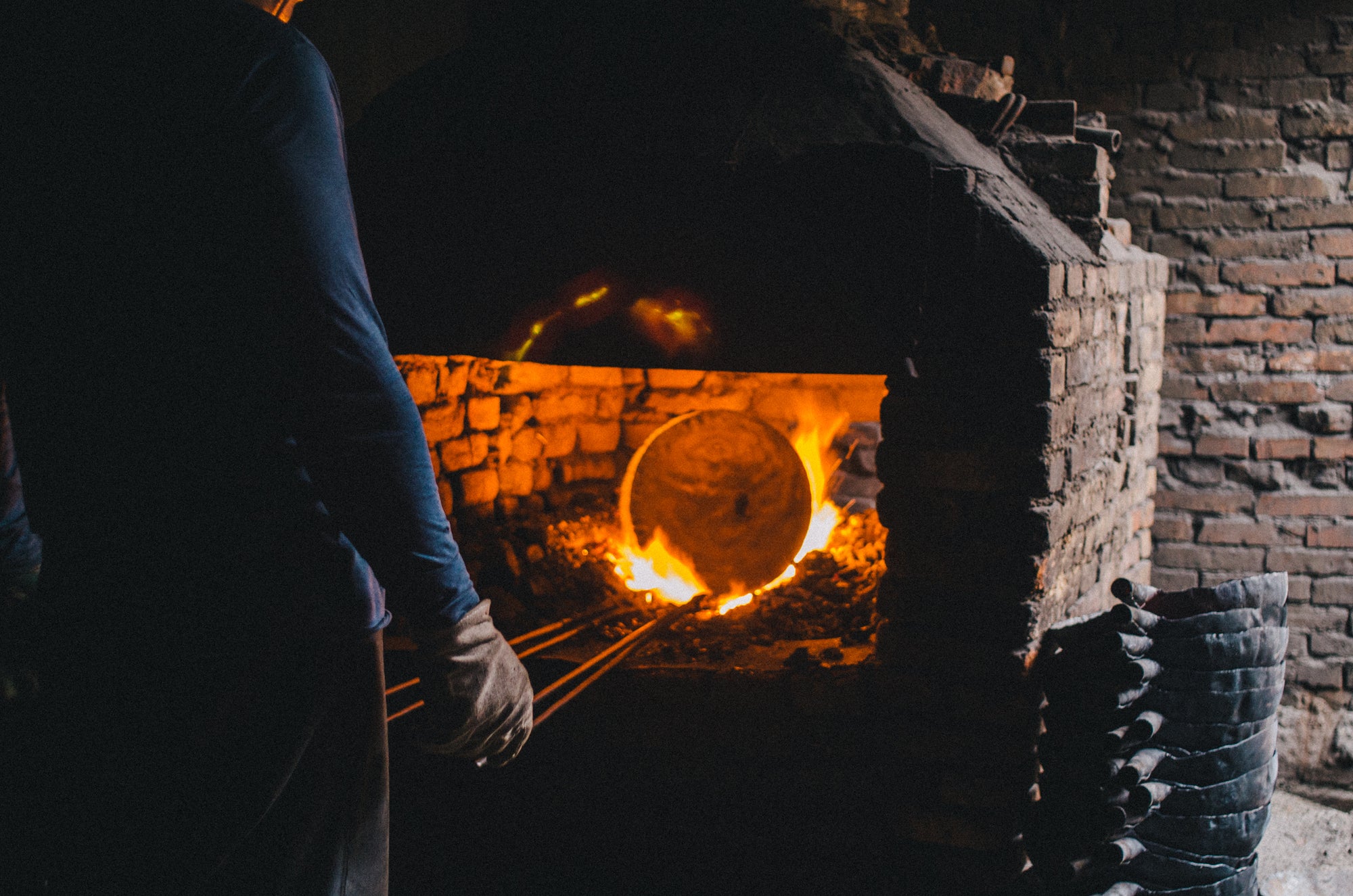 Man forging a wok in a furnace