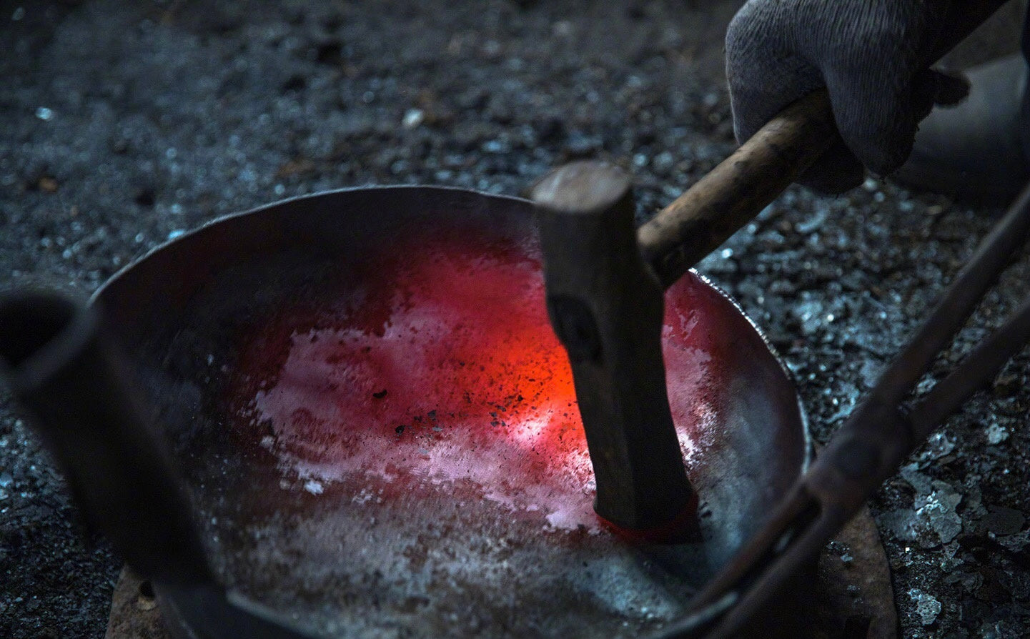 hand hammering a wok